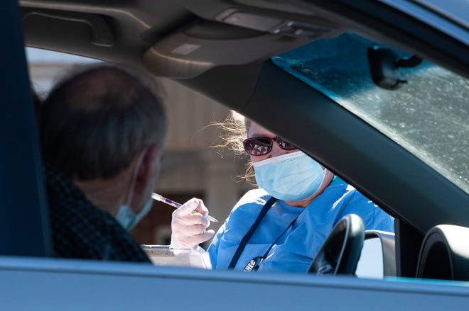 A medical worker takes information from a person at a COVID-19 drive through testing site near Eclectic, Ala., on Monday November 2, 2020.
