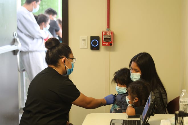 A migrant family transported from the Rio Grande Valley to the El Paso Sector Border Patrol Central Processing Center is given an initial health screening by a contractor who oversees the health and welfare of family units and unaccompanied minors there. They are show March 8, 2021.