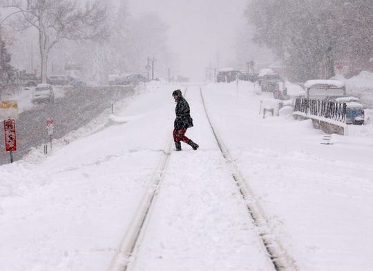 A person crosses the barely visible railroad tracks that go through the Colorado State University campus on March 18, 2003, as snow continued to fall on Fort Collins, Colorado, during that historic snowstorm.