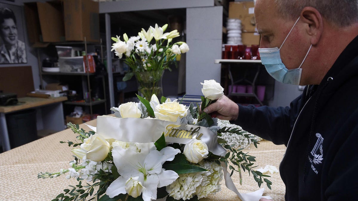 A florist demonstrates how to make floral arrangement for a funeral, amid the Coronavirus pandemic at a floral shop in Arlington, Virginia on February 22, 2021.