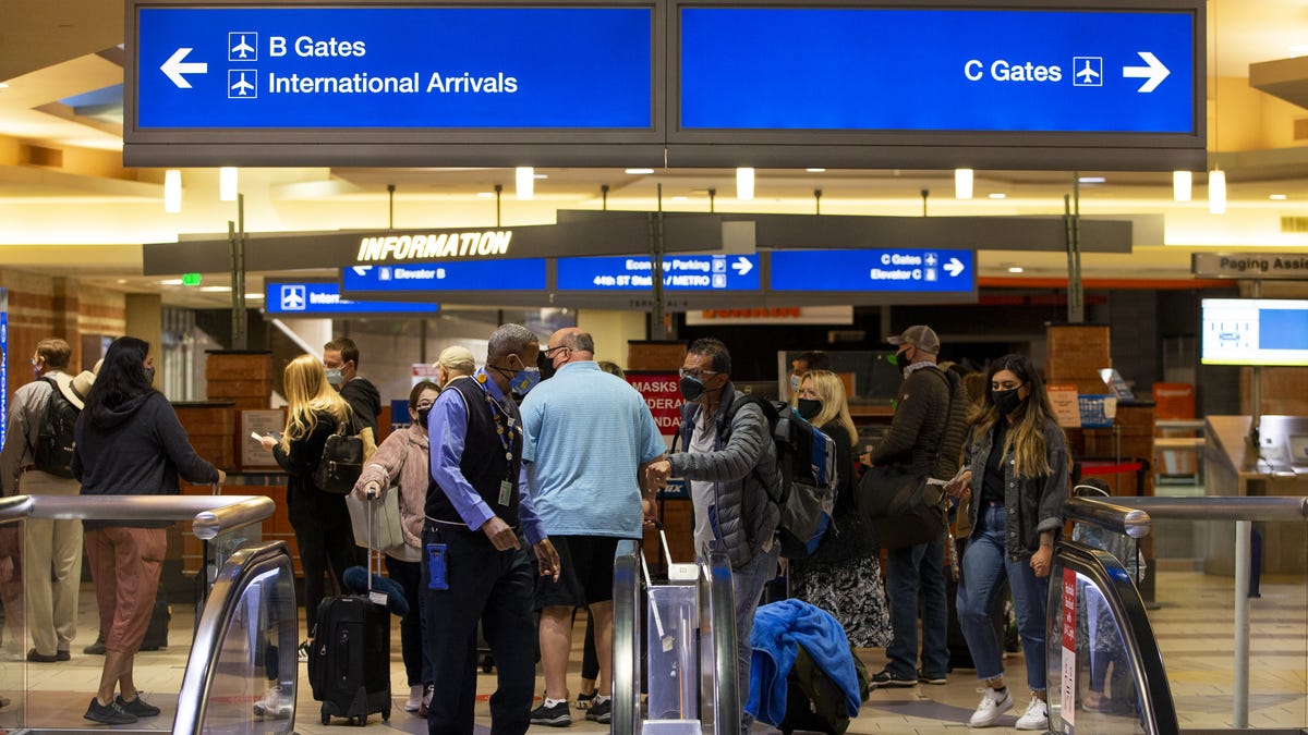 Travelers walk to their gates at Terminal 4 in Sky Harbor International Airport in Phoenix, Ariz., on March 11, 2021.