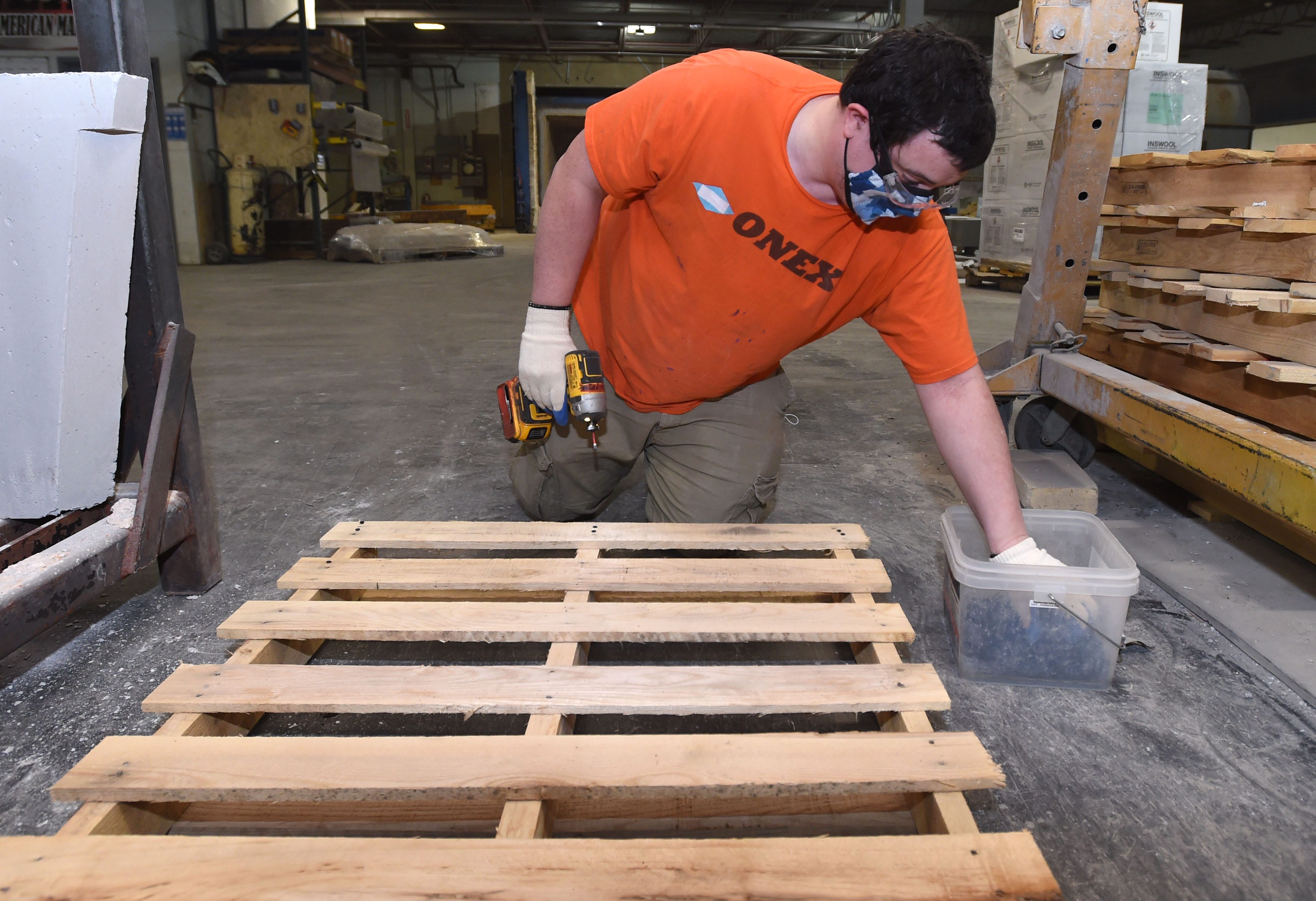 James Minier, a pre-cast specialist at Onex, assembles pallets March 12 at the Erie company. Minier, a client of the Barber National Institute, works part-time at Onex performing a variety of jobs.