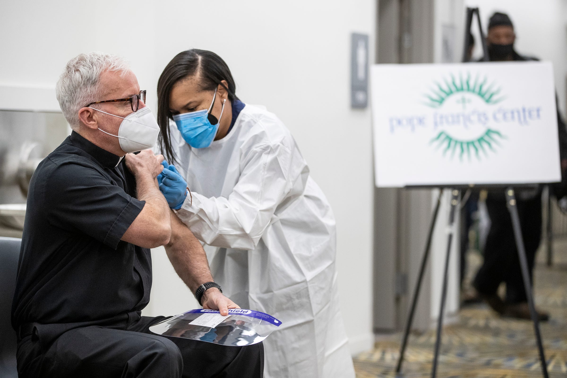Pope Francis Center Executive Director Father Tim McCabe receives his second dose of Covid-19 vaccine at the lower level of TCF Center in Detroit on Feb. 11, 2021.