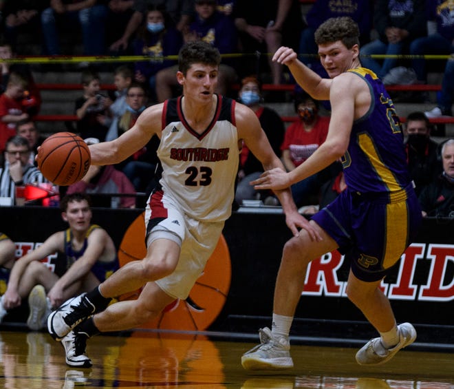 Southridge’s Colson Montgomery (23) drives the ball past Paoli’s Issac Cornett-McBride (20) during the IHSAA Class 2A boys basketball regional at Memorial Gym in Huntingburg, Ind., Saturday, March 13, 2021. The Raiders defeated the Rams, 43-35, to advance to the regional championship. 