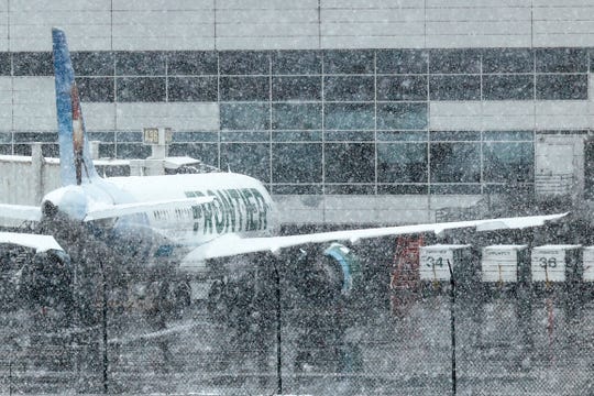 A Frontier Airlines plane sits at a gate at Denver International Airport on March 13, 2021, in Denver.