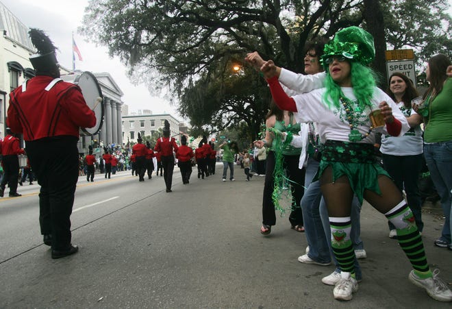 Parade goers dance as a marching band passes along Bay Street during the 2010 St. Patrick's Day Parade.