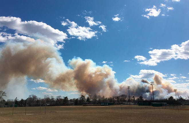 Smoke billows from a brush fire in Lakewood, N.J., that shut down the Garden State Parkway on Sunday, March 14, 2021. (Kevin Shea/NJ Advance Media via AP)