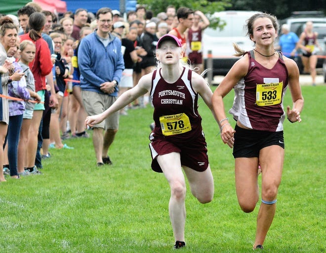 Portsmouth Christian Academy’s Liza Corso, left, races to the finish line during her sophomore season at the Bobcat Cross Country Invitational in Madbury.