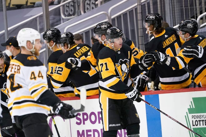 Pittsburgh's Evgeni Malkin celebrates with teammates on the bench after scoring as Boston's Steve Kampfer skates by during the second period of Monday's game.