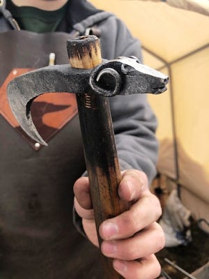 Nicholas Riolo, 17, of Bellingham, shows a tool with a ram's head he crafted for himself, created from a railroad spike and an antique wooden handle.