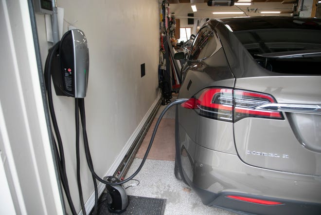 Saline homeowner Bruce Westlake, 70, shows his electric vehicle charging station with a 2016 Tesla Model X 90D at his home on Mar. 16, 2021. Westlake relies on solar power to power his home and recharge his cars.
