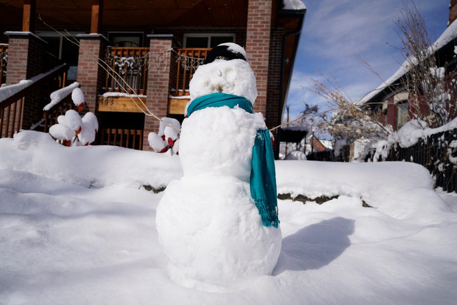 A snowman stands in front of a home in Denver after a major storm dumped up to two feet of snow in its wake Monday, March 15, 2021.