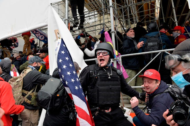 A man in a ballistic helmet and cloth plate carrier calls on people to raid the U.S. Capitol as supporters of President Donald Trump clash with police and security forces in Washington, D.C., on Jan. 6.
