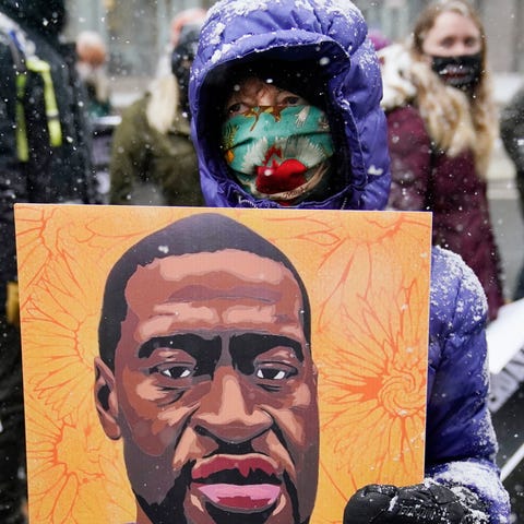 A protester carries a portrait of George Floyd dur