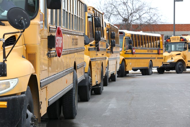 Buses wait to take students home after school on Tuesday, March 16, 2021, outside Belvidere South Middle School.