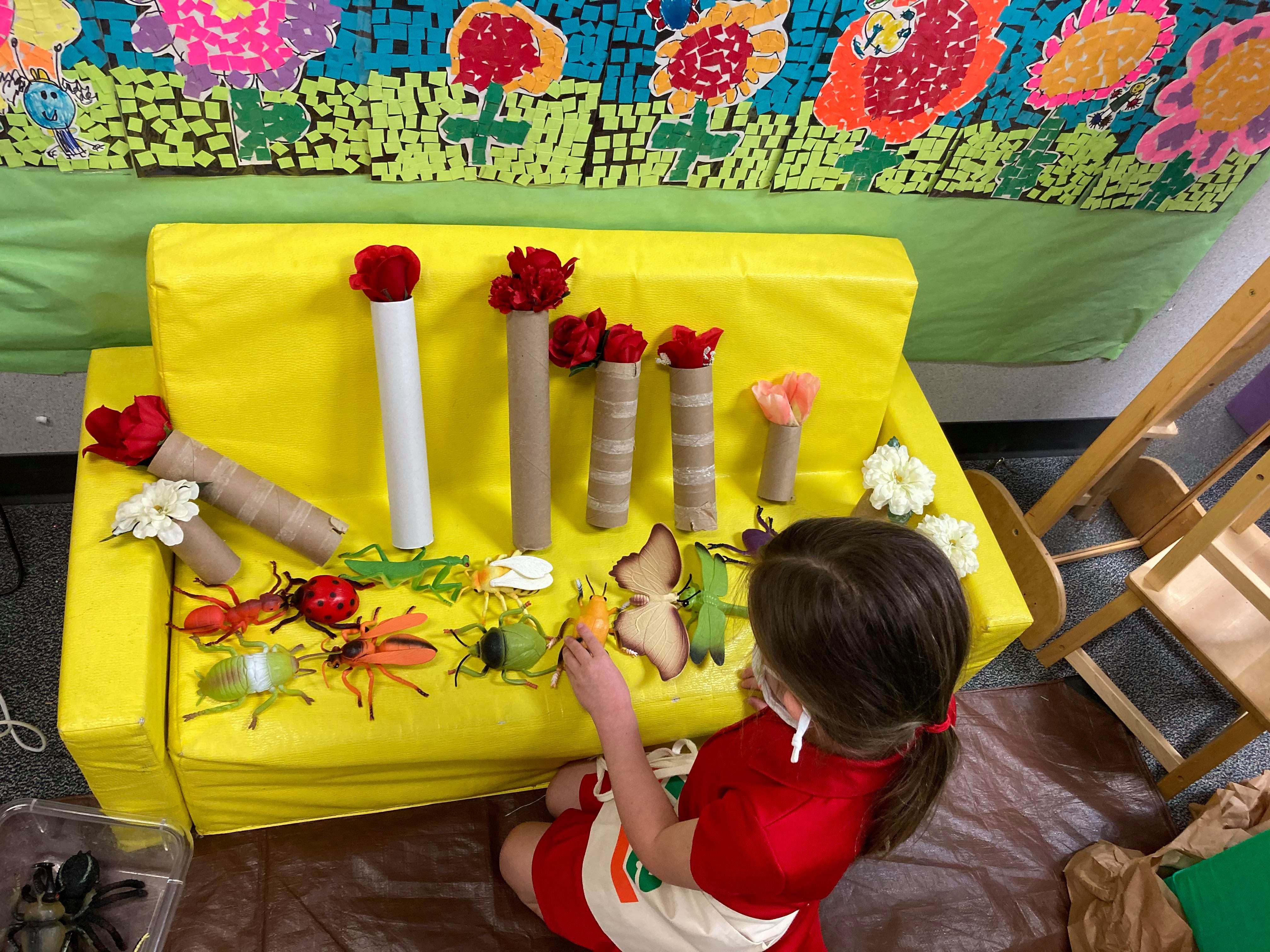 Students in Julia Lopez's pre-K Spanish immersion class at Charles M. Burkey Elementary learn while playing in centers that follow different themes throughout the year. As part of the spring theme, students are sorting giant bugs and creating flower bouquets for their parents.