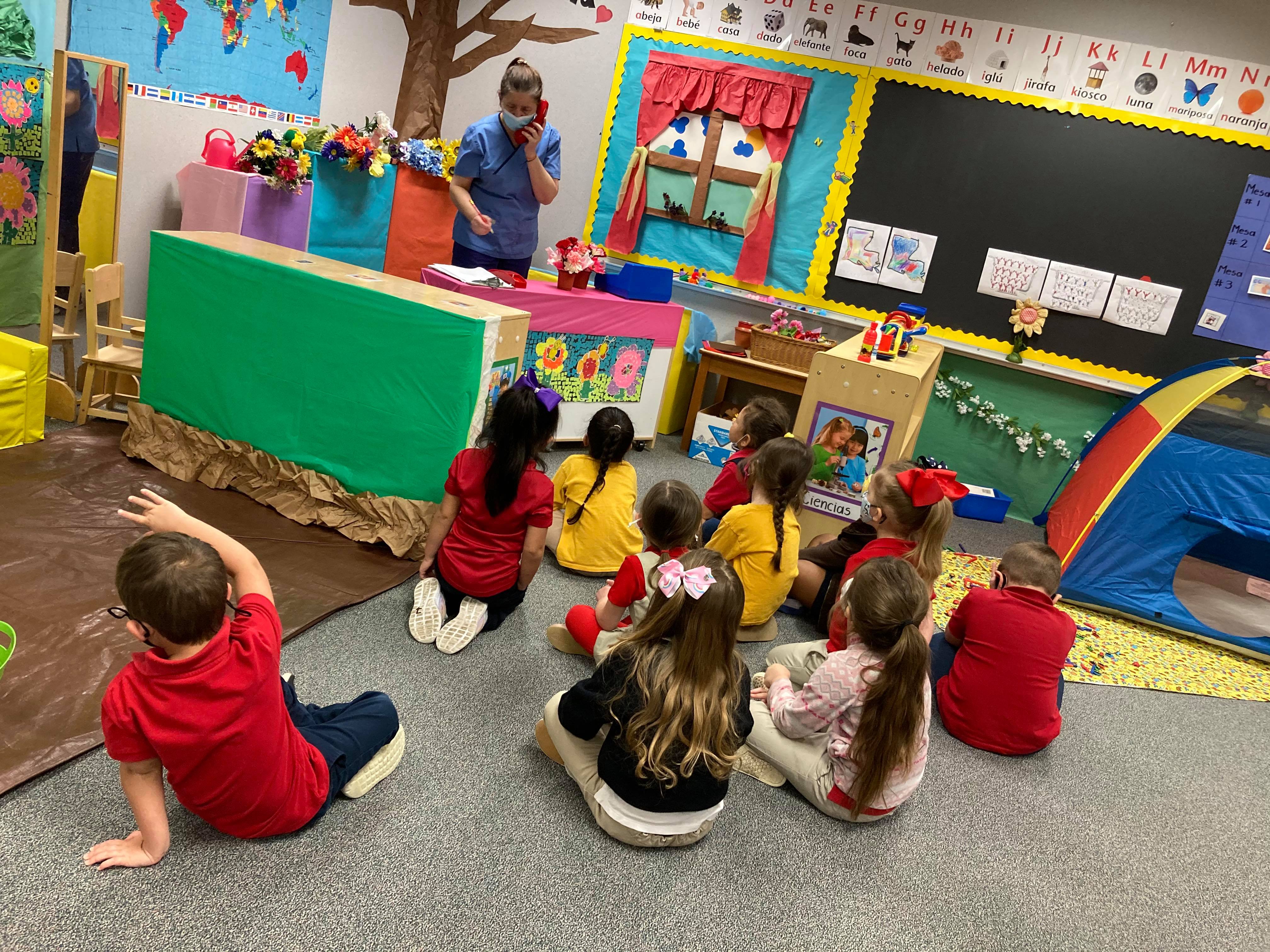 Julia Lopez, a pre-K Spanish immersion teacher at Charles M. Burke Elementary, says this year of teaching has been an emotional and special one. Here, she answers a play phone before her 4-year-old students.