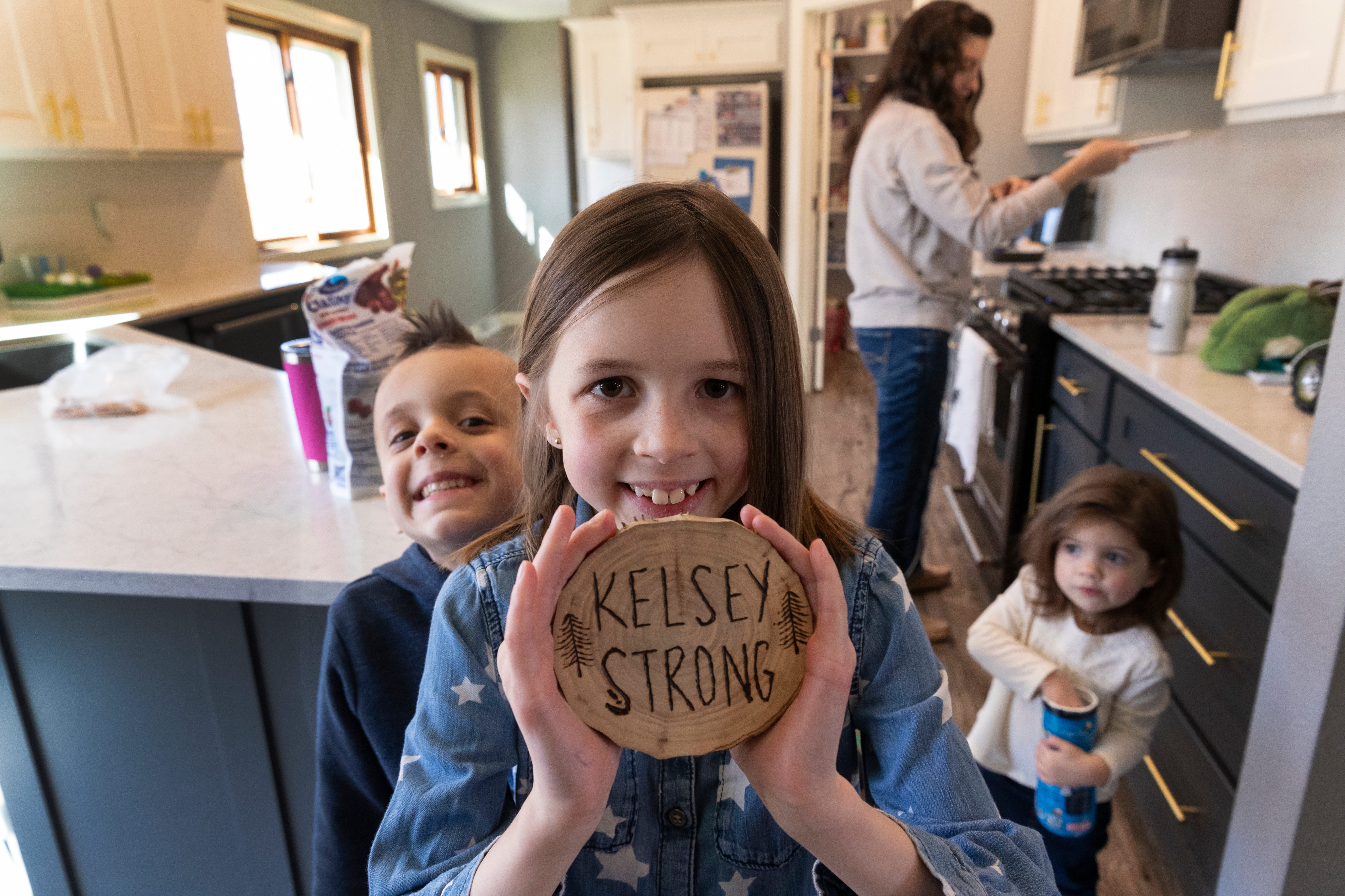 Payton Townsend holds some inspirational artwork made while her mother was hospitalized critically ill with COVID-19. She is shown with siblings Beau, 5, and Faith,1½, at their home in Poynette.