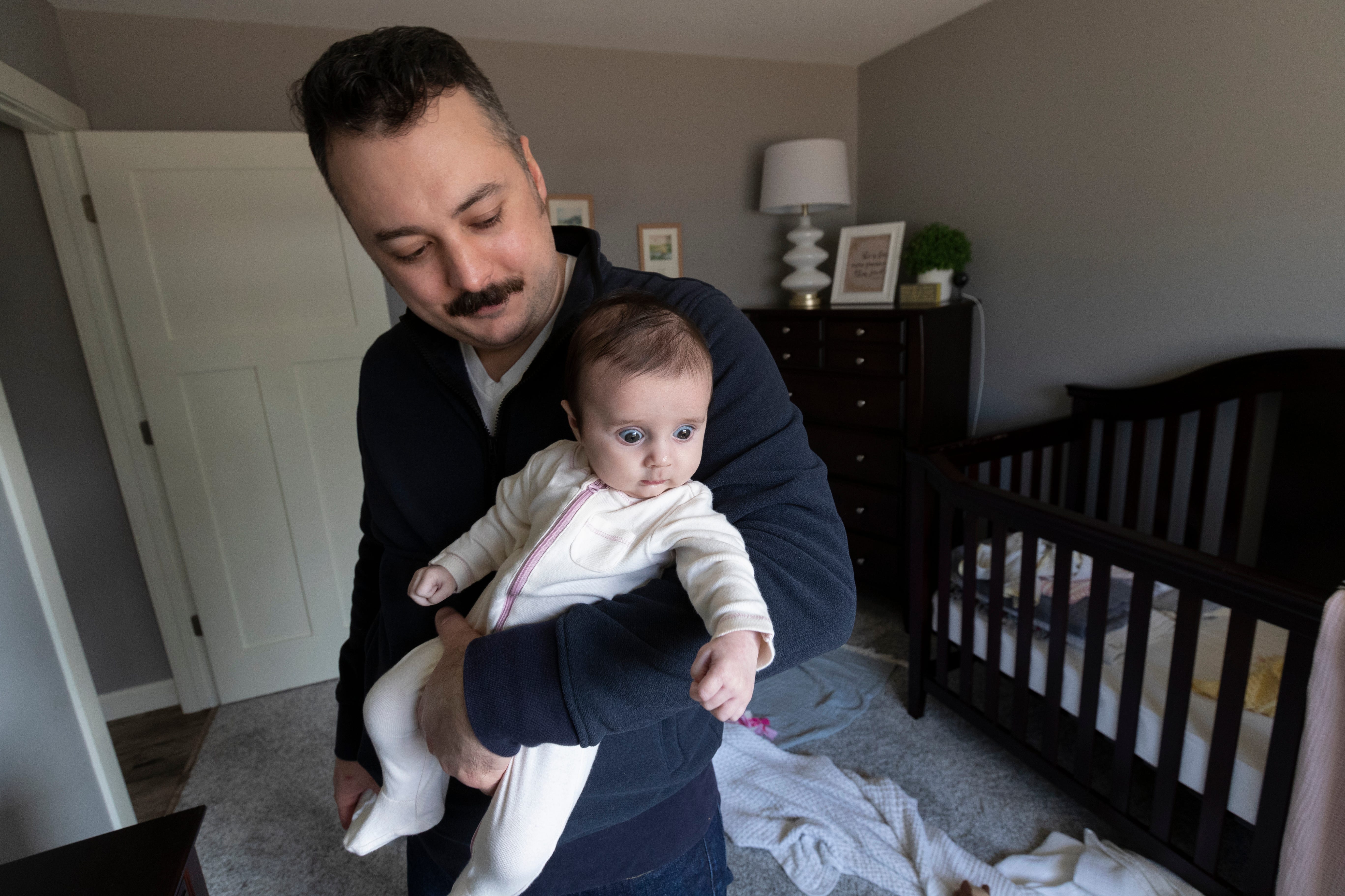 Derek Townsend holds Lucy Kyu at their home March 12 in Poynette.