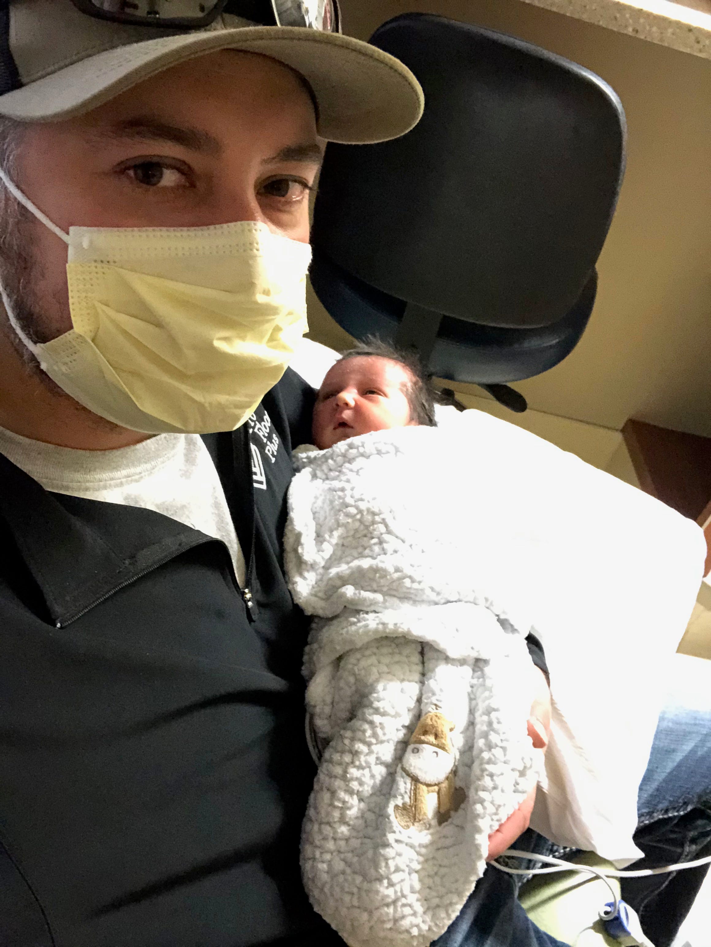 Derek Townsend holds his newborn daughter Lucy Kyu Townsend.