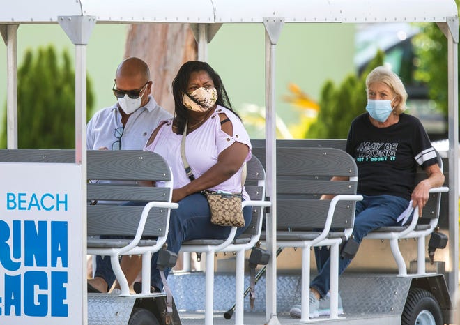 People are brought by tram from the parking lot to the Wells Recreation Center in Riviera Beach for their Covid-19 vaccinations Thursday, March 18, 2021.