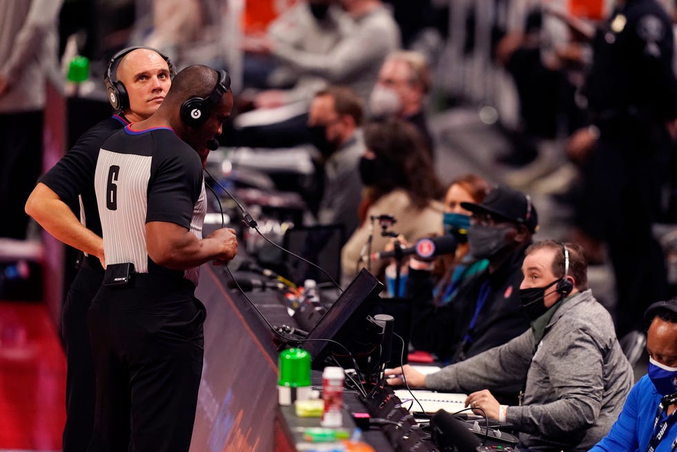 Referees Jacyn Goble, left, and Tony Brown (6) review a play during the first half of an NBA basketball game between the Detroit Pistons and the Toronto Raptors, Wednesday, March 17, 2021, in Detroit.
