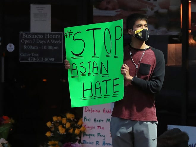 Jesus Estrella, of Kennesaw, Ga., stands outside Youngs Asian Massage on Wednesday, March 17, 2021, in Acworth, Ga., where four people were fatally shot Tuesday. 