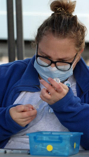 Paris Hermon fills syringes with vaccine as Kintegra Health and Livent teamed up Friday to host a free drive through COVID-19 vaccination clinic in the Livent parking area on Bessemer City-Kings Mountain Highway.