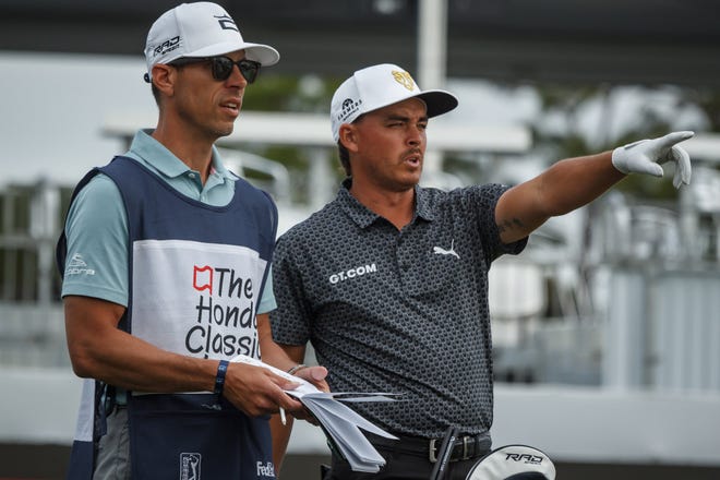On the 17th tee, Rickie Fowler, right, talks with his caddy during the second-round action of The Honda Classic at PGA National in Palm Beach Gardens on Friday.