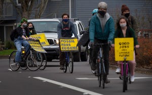 Protesters ride through the streets of Eugene on their way to NW Natural offices in Eugene during a protest of fossil fuel use.