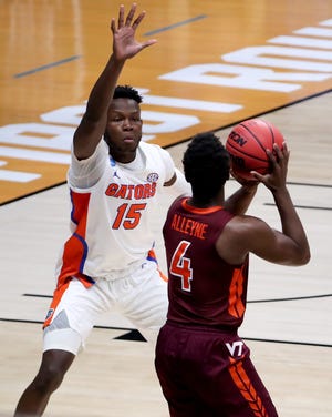 Virginia Tech Hokies guard Nahiem Alleyne (4) looks to pass as Florida Gators forward Osayi Osifo (15) defends in the first half during a first-round game of the 2021 NCAA Tournament on Friday, March 19, 2021, at Hinkle Fieldhouse in Indianapolis, Ind.