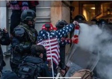 Robert Palmer of Largo, Fla., wearing the flag jacket, was sentenced in December to 63 months in jail for assaulting law enforcement with dangerous weapons.