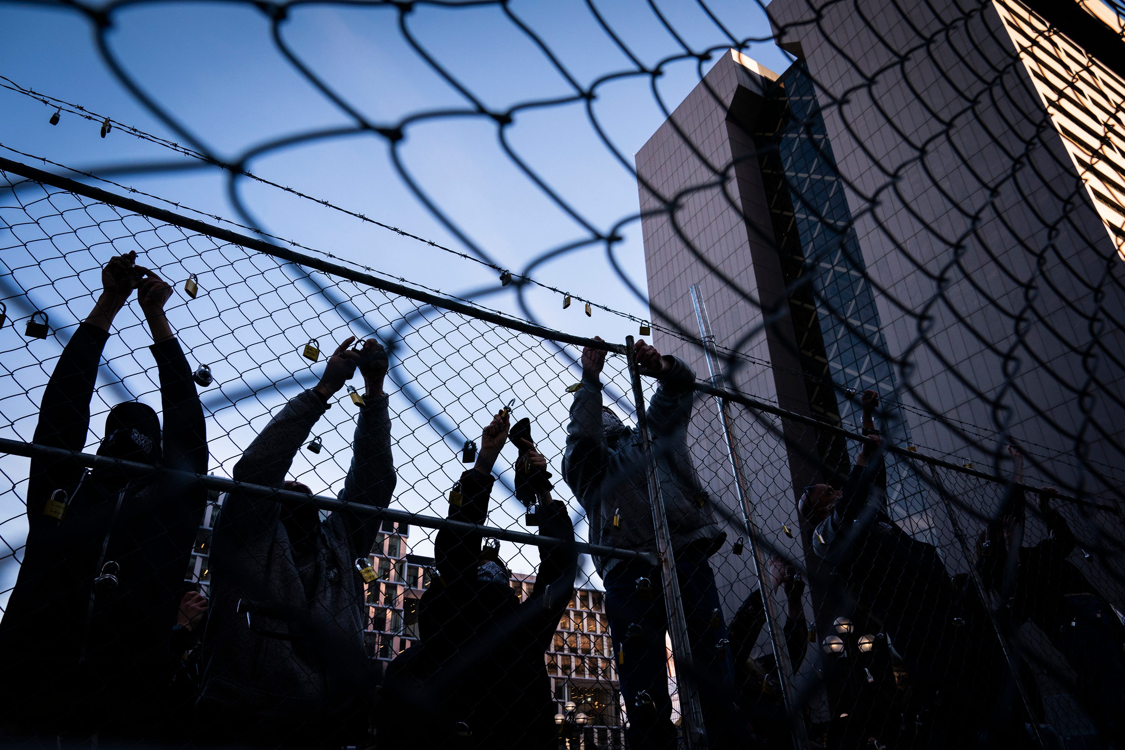 People place locks with the names of those killed by law enforcement in Minnesota on the fence outside the Hennepin County Government Center during the "Locks for Loved Ones Lost: Part II" event, Thursday, March 18, 2021, in Minneapolis. Attorneys at the trial of former Minneapolis Police Officer Derek Chauvin, who is charged in George Floyd’s death, have moved closer to seating a full jury.