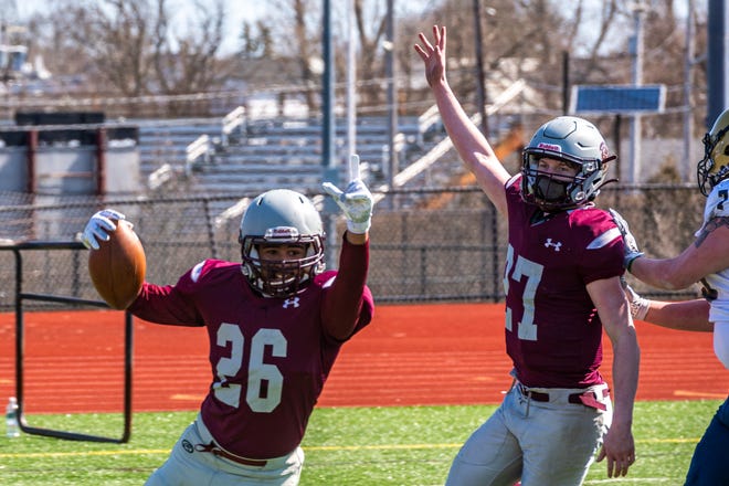 Bishop Stang's Carlo Acosta celebrates his fumble recovery and touchdown for the Spartans.