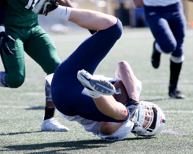 Rockland’s Jacob Moore rolls on his back after making the interception to seal their win over Abington at Hingham High on Saturday, March 20, 2021.