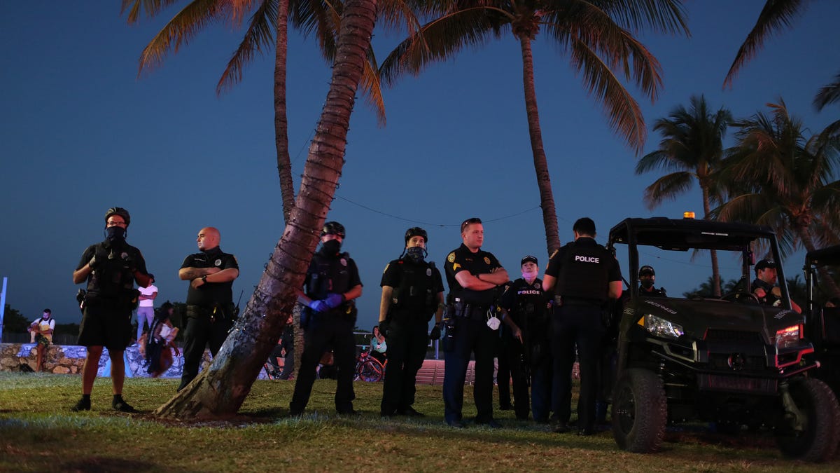 Miami Beach police officers stand on patrol along Ocean Drive on March 21, 2021 in Miami Beach, Florida.
