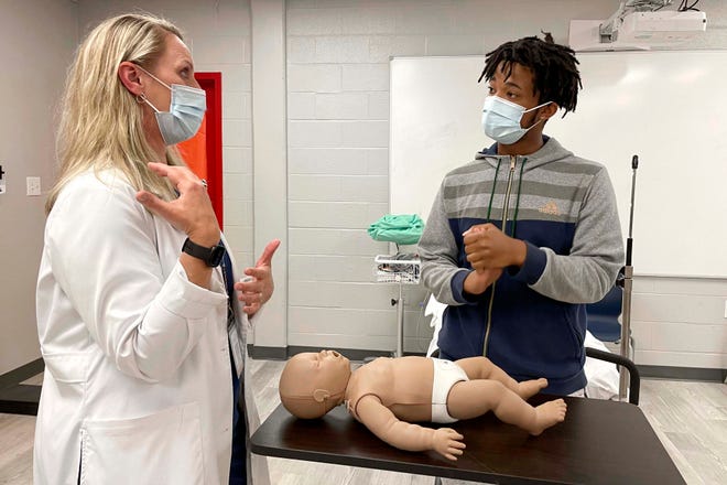 Crestview High School junior Savion Harris talks with Dr. Tammy McKenzie, one of his instructors at the school, about the CPR techniques he used recently to help save a 6-month-old child who was not breathing. Harris learned CPR this year in one of his classes in the school's Career Technical Education curriculum.