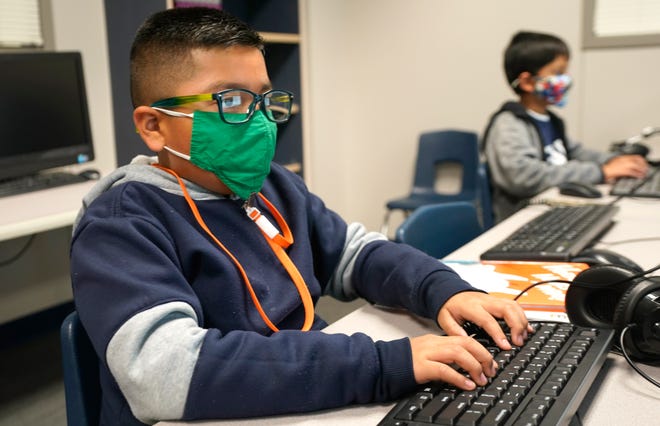 FILE - In this Dec. 3, 2020, file photo, students wearing face masks work on computers at Tibbals Elementary School in Murphy, Texas. A new poll from The University of Chicago Harris School of Public Policy and The Associated Press-NORC Center for Public Affairs Research finds that most parents fear that their children are falling behind in school while at home during the pandemic (AP Photo/LM Otero, File)