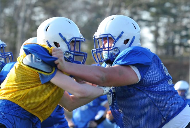 Scituate right guard Michael Sheskey, right, pushes back a defender during practice, Tuesday, March 23, 2021.