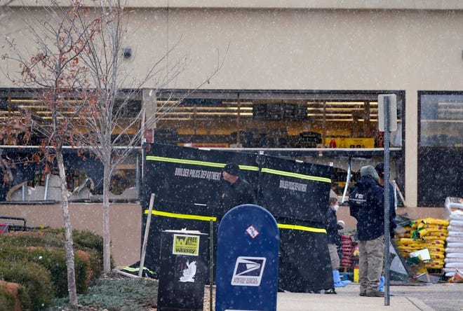 Snow falls as investigators continue to collect evidence in the parking lot where a mass shooting took place at a King Soopers grocery store Tuesday, March 23, 2021, in Boulder, Colo. (AP Photo/David Zalubowski)