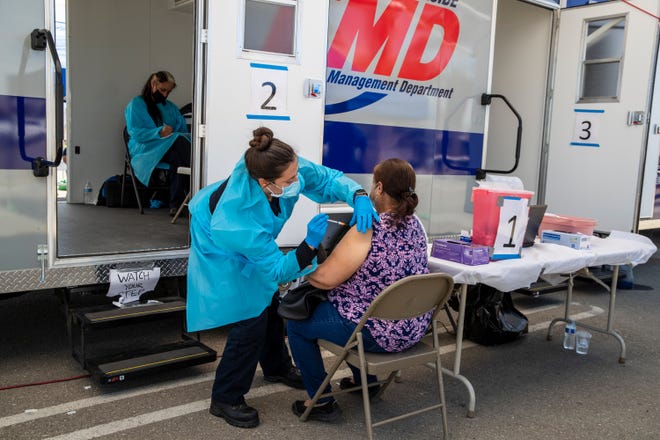 Emergency Medical Technician Sharon Lopez administers the Pfizer COViD-19 vaccine to a Mecca resident during a Riverside County mobile vaccine clinic in Mecca Calif., on March 24, 2021. 