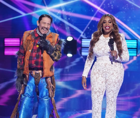On the March 24 episode of Fox's 'The Masked Singer,' Raccoon, the latest eliminated contestant, was revealed to be Danny Trejo, left. He was joined on stage by host Niecy Nash.