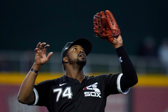 Chicago White Sox left fielder Eloy Jimenez reaches up to make a catch on a fly ball hit by Cincinnati Reds outfielder Tyler Naquin during the second inning of a spring training game Thursday, March 11, 2021, in Goodyear, Ariz.