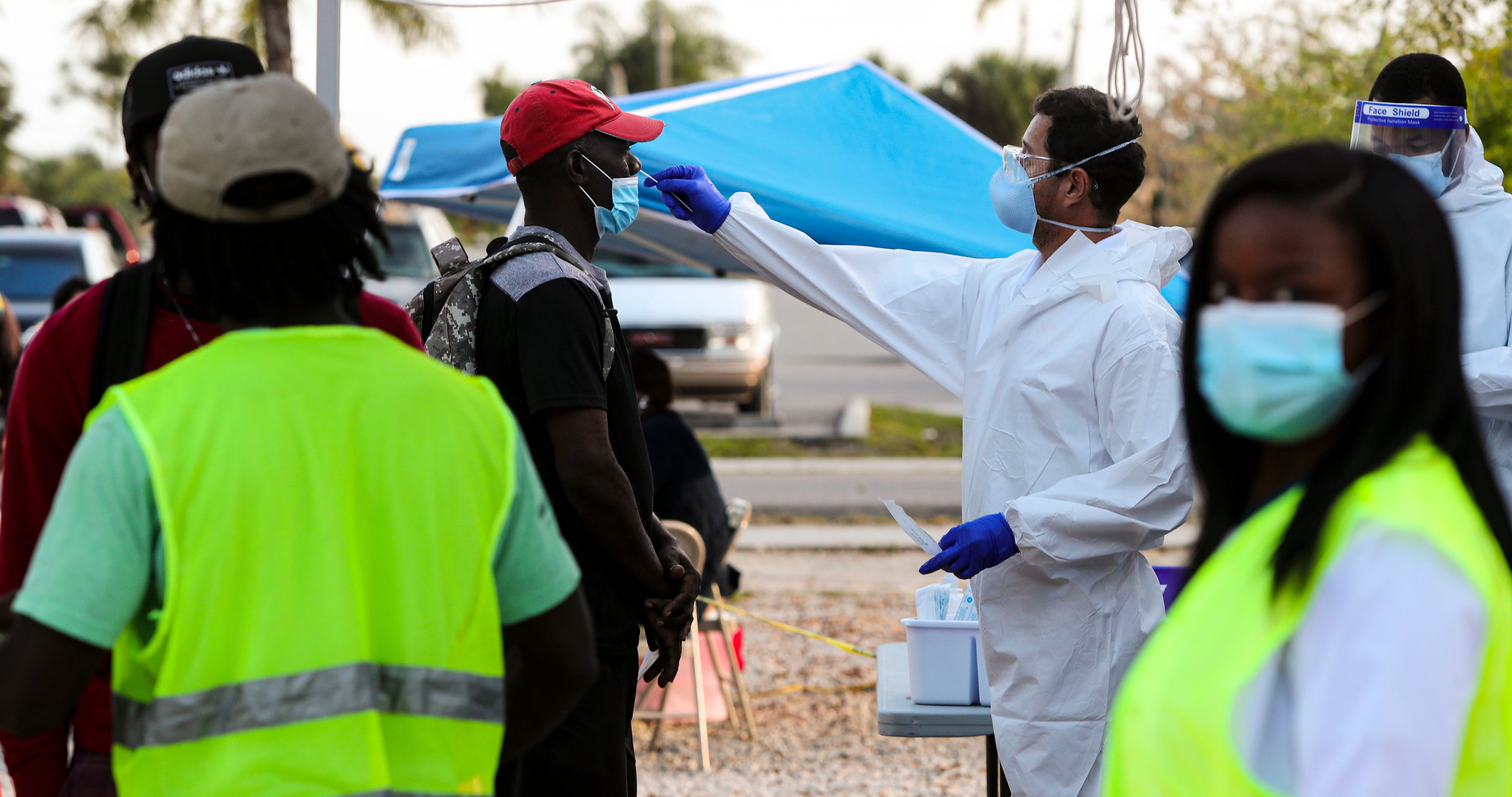 Edwin Canas administers a COVID test to a farmworker. Busses drop off migrant farmworkers in the center of town, near CIW and Mision Peniel, in Immokalee. COVID-19 Rapid tests, education and results are provided by a Healthcare Network, CIW, working together with PIH to address the unique needs of this heavily immigrant community.