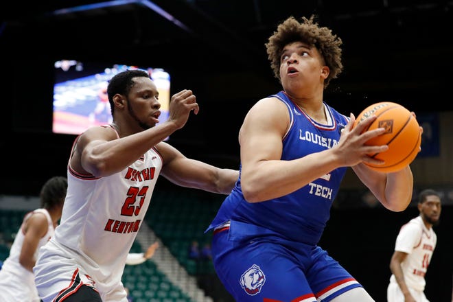 Louisiana Tech’s Kenneth Lofton, Jr. is guarded by Western Kentucky's Charles Bassey during the NIT basketball tournament on March 25, 2021.