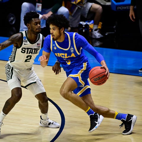 UCLA guard Johnny Juzang drives against Michigan S