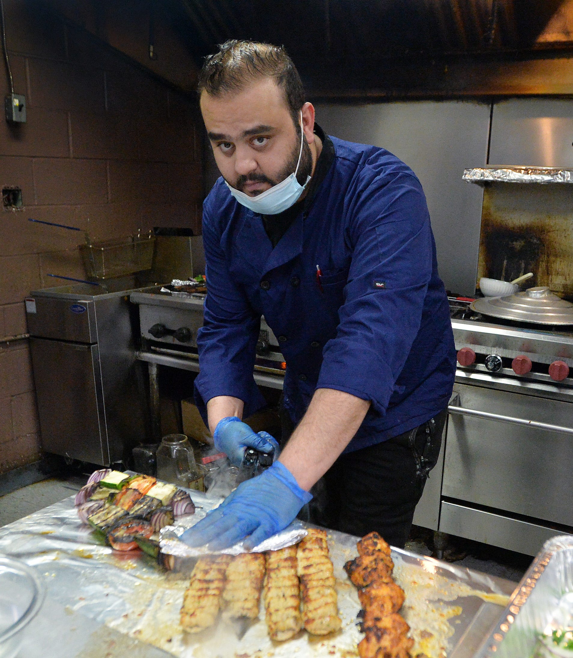 Shish Kabob restaurant owner and chef Sohaib Kareem, 28, prepares chicken and vegetable skewers on March 27, 2021, in Erie. He said during the COVID-19 pandemic that Ramadan is not celebrated with large gatherings as in normal years. He said his business also fluctuates between being very busy or not at all, which makes planning difficult. 