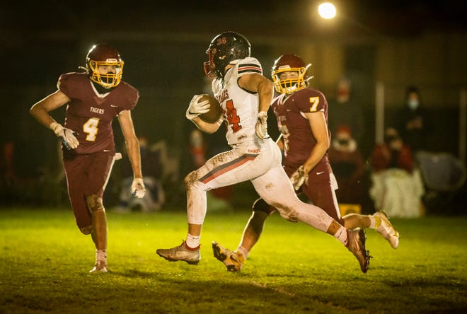 Santiam Christian's Heston Bain is pursued by Junction City's Nick White and Chase Emanuel (7) during Friday's game at Junction City. Santiam Christian won 34-7.