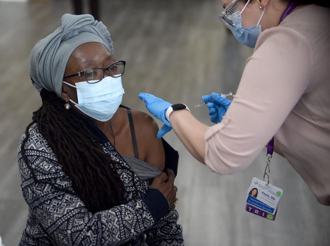 Dee Flowers of Hartford receives her first dose of Pfizer's COVID-19 vaccine on Feb. 16 at The First Cathedral Church in Hartford. Administering the vaccine is St. Francis Hospital registered nurse Kayla Bennett.