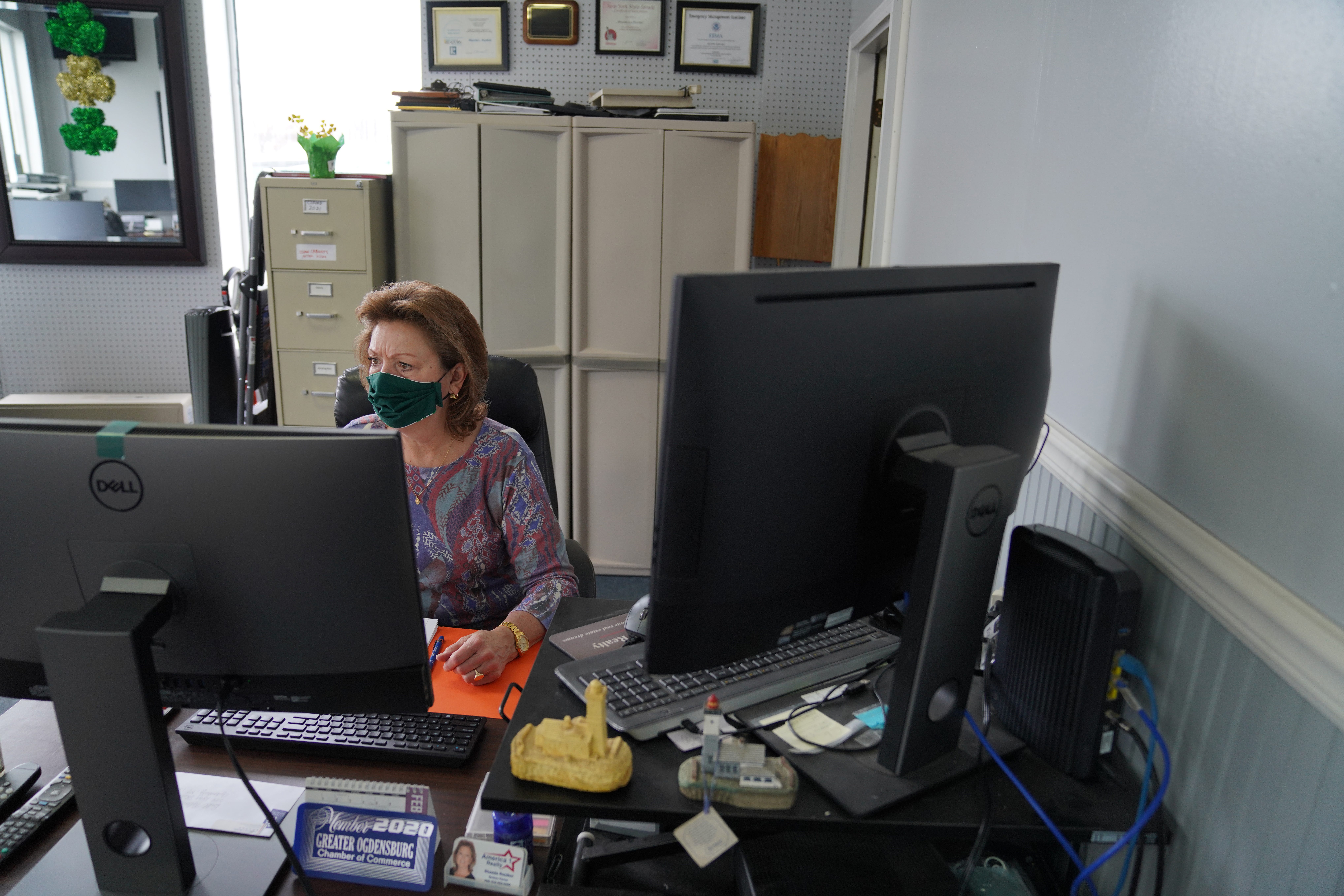 Rhonda Roethel sits at a desk in her real estate office in Ogdensburg. She said real estate demand for property in and around Ogdensburg is a rare bright spot in the city's economy. Buyers, she said, are coming to the St. Lawrence River community from as far away as New York and Los Angeles.